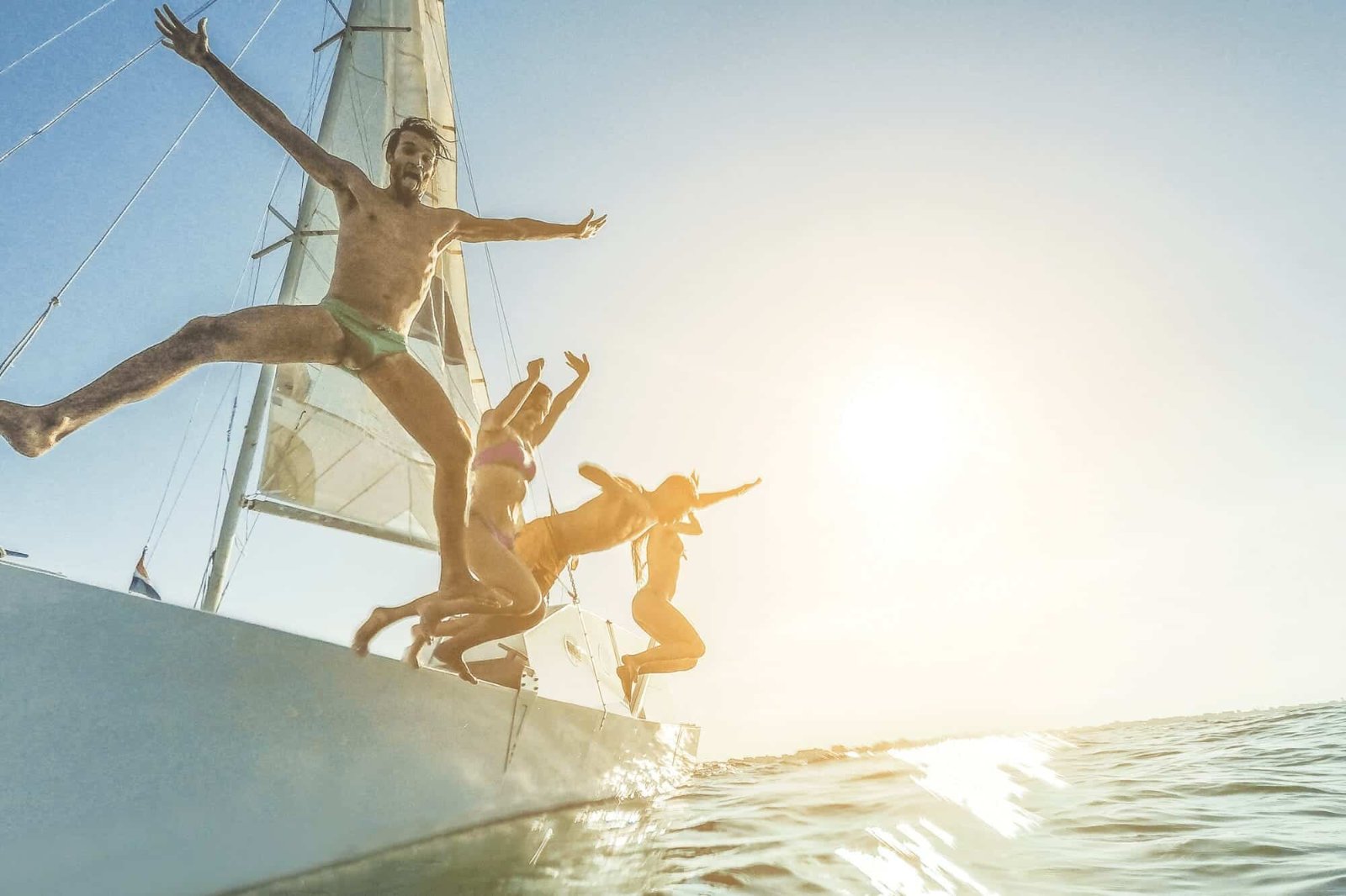 Friends diving into the sea off a boat